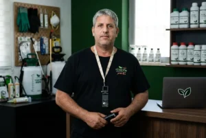 פורטרט מקצועי של שגיא המדביר, במדי עבודה, עם מבט בטוח וציוד מקצועי ברקע.